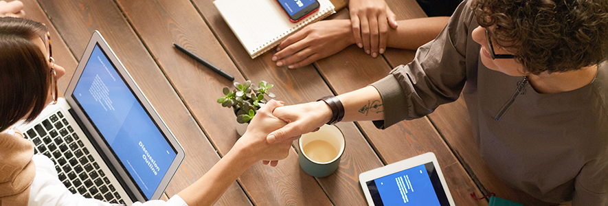 two people shaking hands over the table